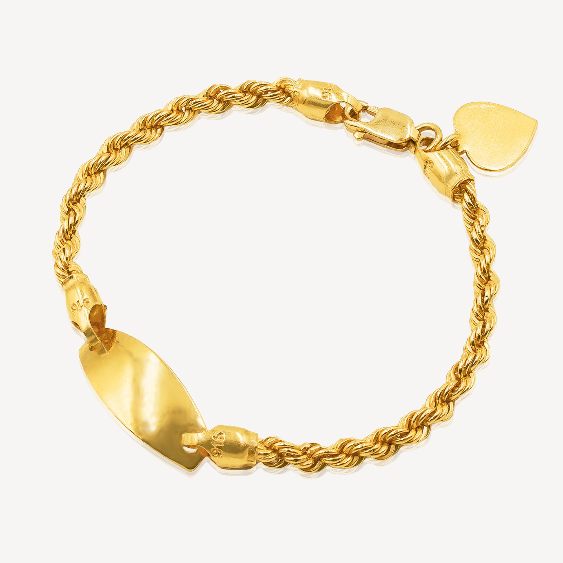 Gold bracelet with rope design and heart-shaped tag on a white background